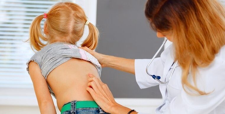 doctor examines a child's back for low back pain